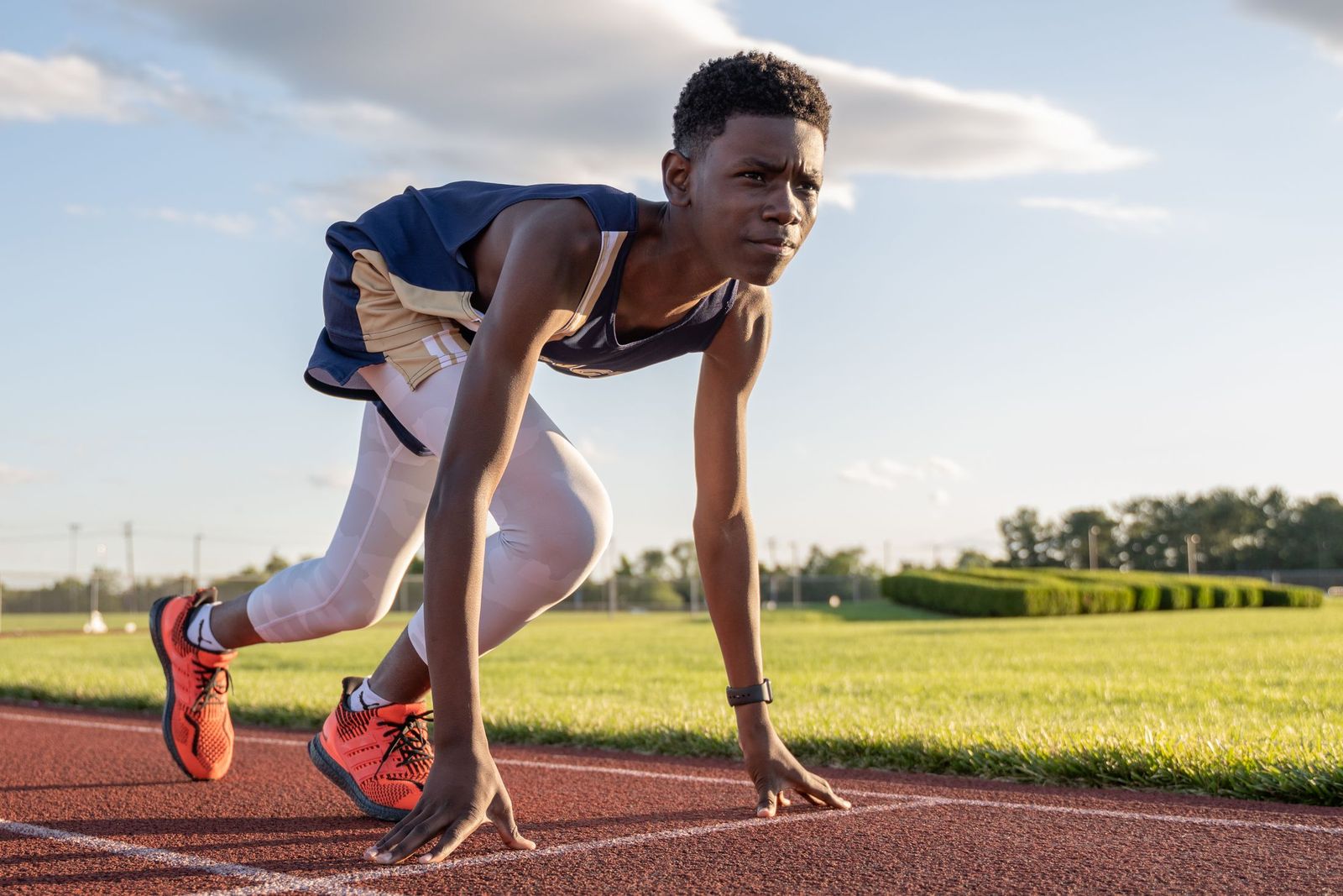 Young athlete in starting position on an outdoor track